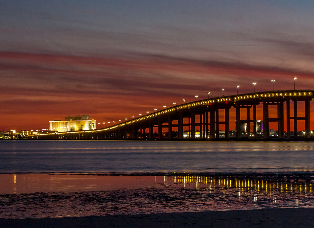 Insurance Solutions - Bridge Lit Up During a Red Evening Sky by the Beach
